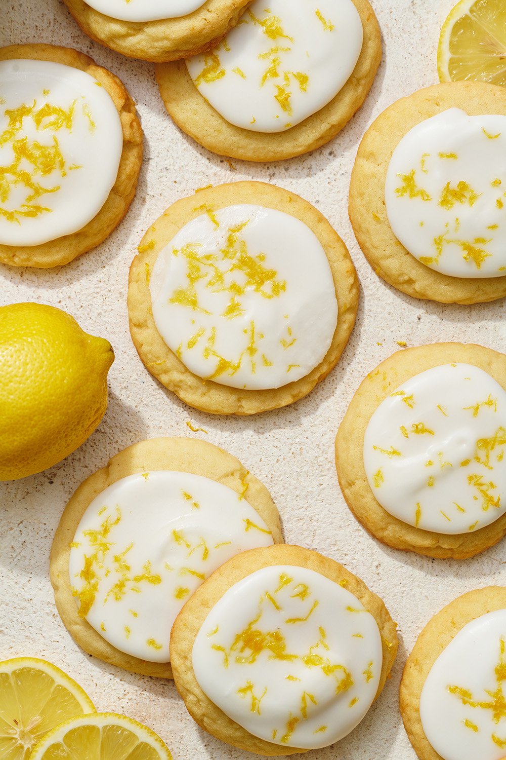 glazed lemon cookies with icing and fresh lemon zest on top, ready to pack up for a summer picnic! 