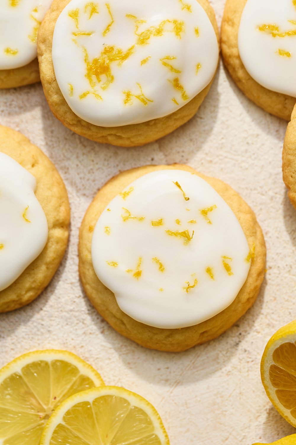glazed lemon sugar cookies with icing and fresh lemon zest on top