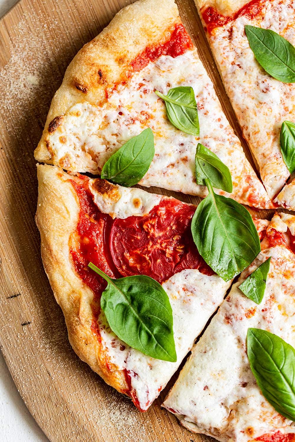 slices of homemade pizza on a wooden pizza peel.