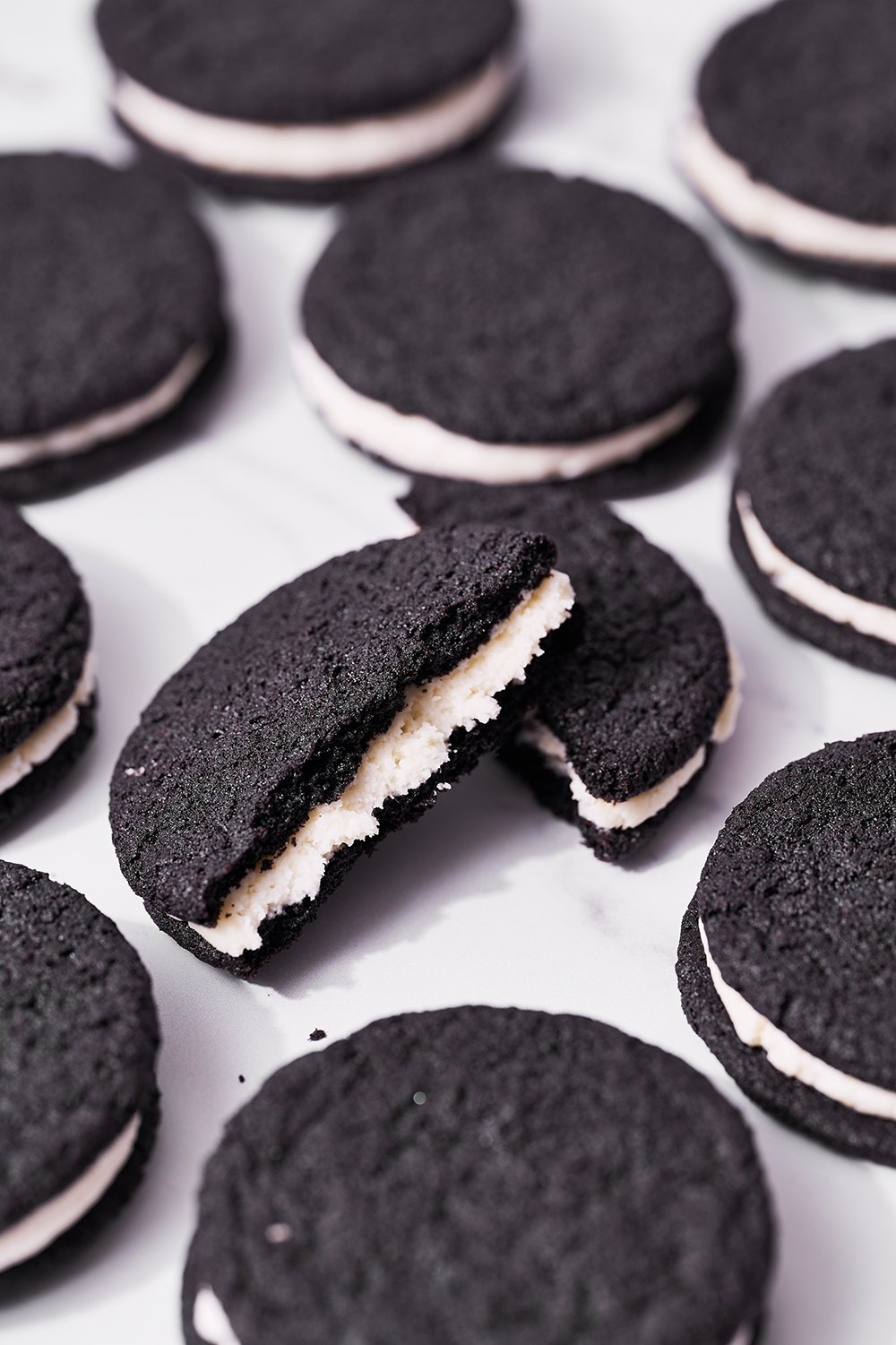 homemade oreo cookies cut in half to see vanilla filling.