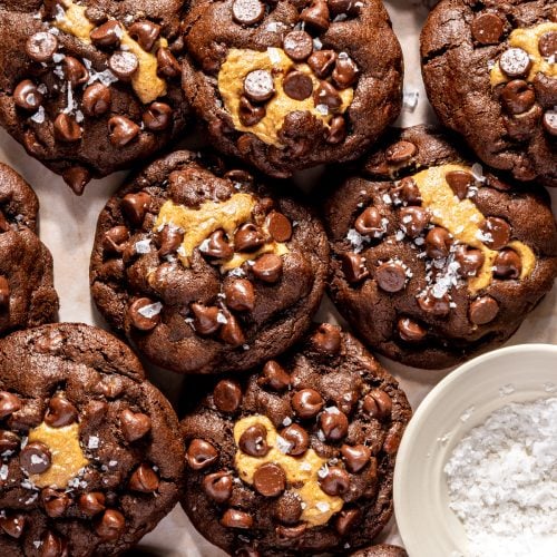 platter of peanut butter stuffed chocolate cookies with a pinch bowl of flaky sea salt