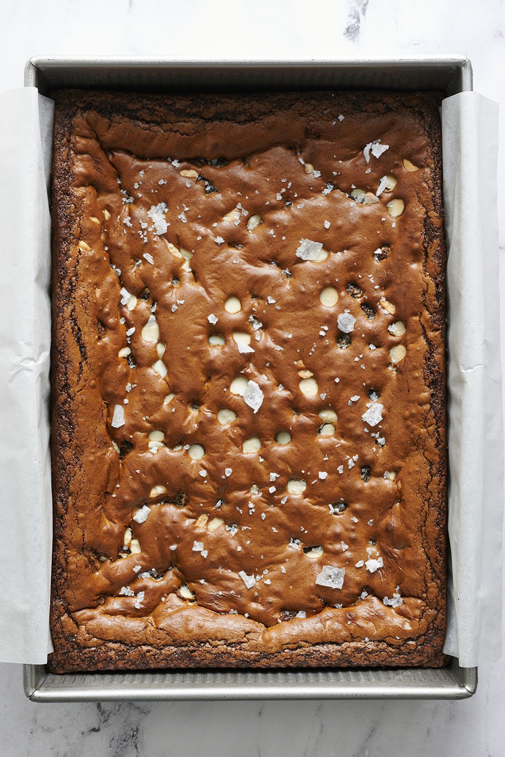 Freshly baked Gingerbread White Chocolate Blondies in a 9x13 pan with a little flaky sea salt on top.