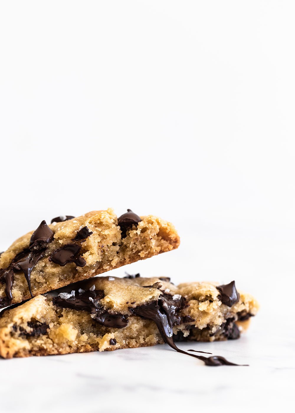 Giant chocolate chip cookies cut in half with gooey chocolate
