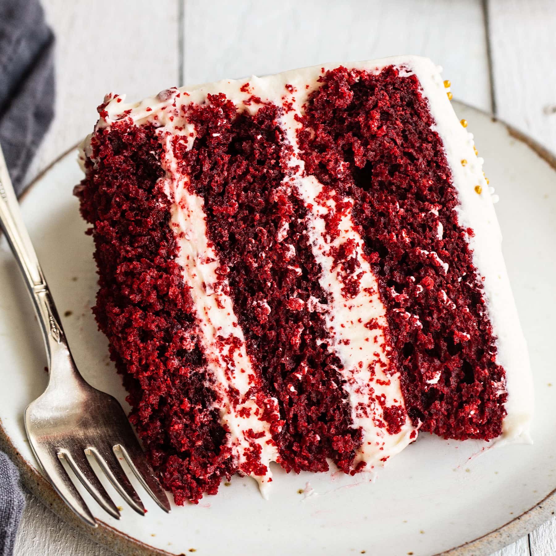 slice of the best red velvet cake recipe made with buttermilk and cocoa powder