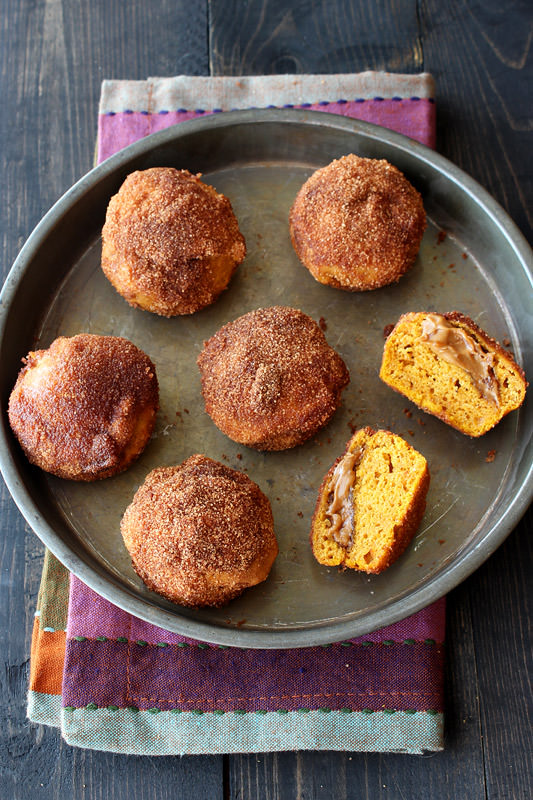 Biscoff Stuffed Pumpkin Mini Muffins are coated with cinnamon sugar and perfect for fall! From HandletheHeat.com