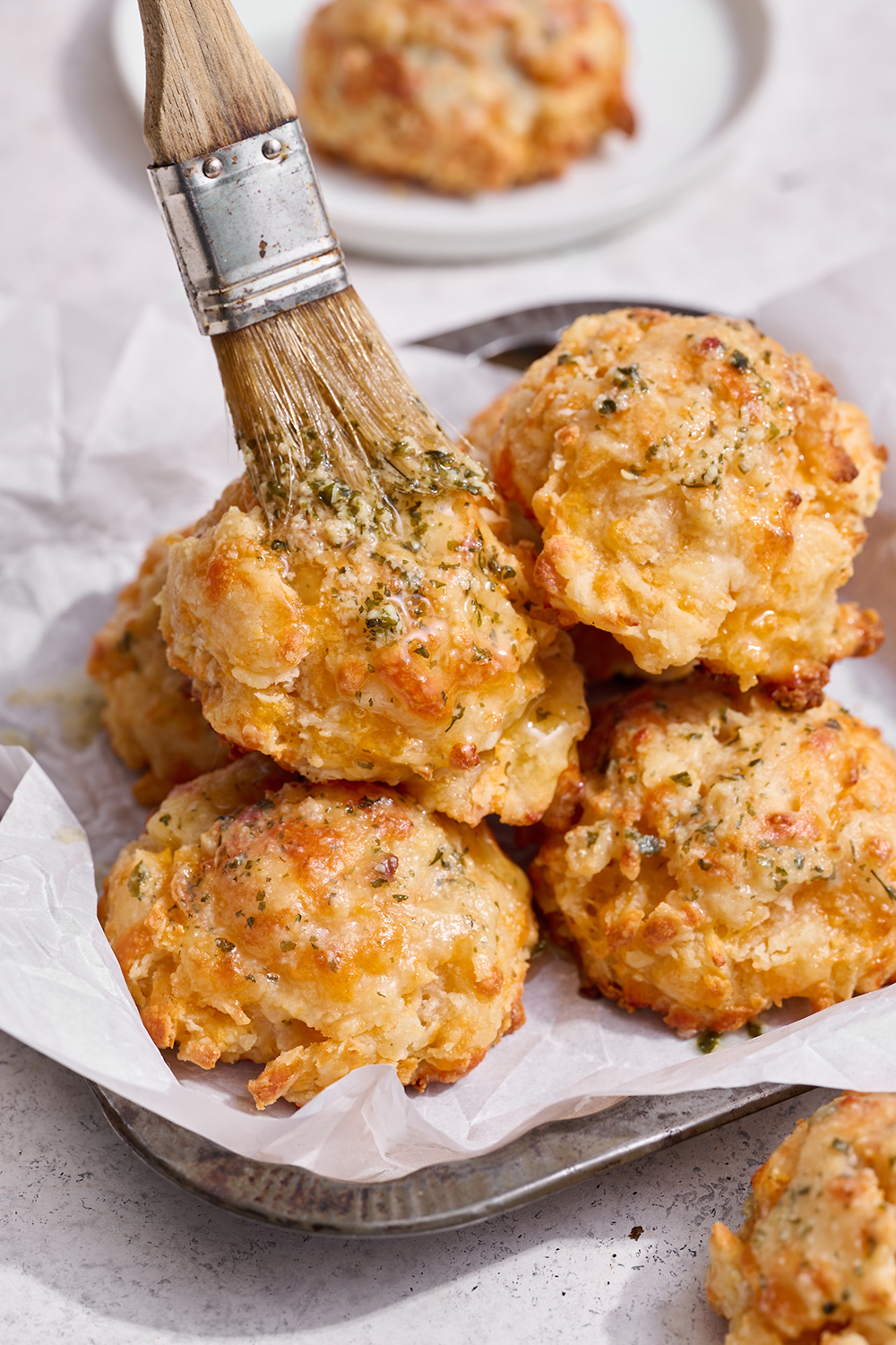 homemade copycat red lobster biscuits being brushed with garlic butter