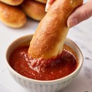 copycat olive garden breadstick being dunked into marinara dipping sauce