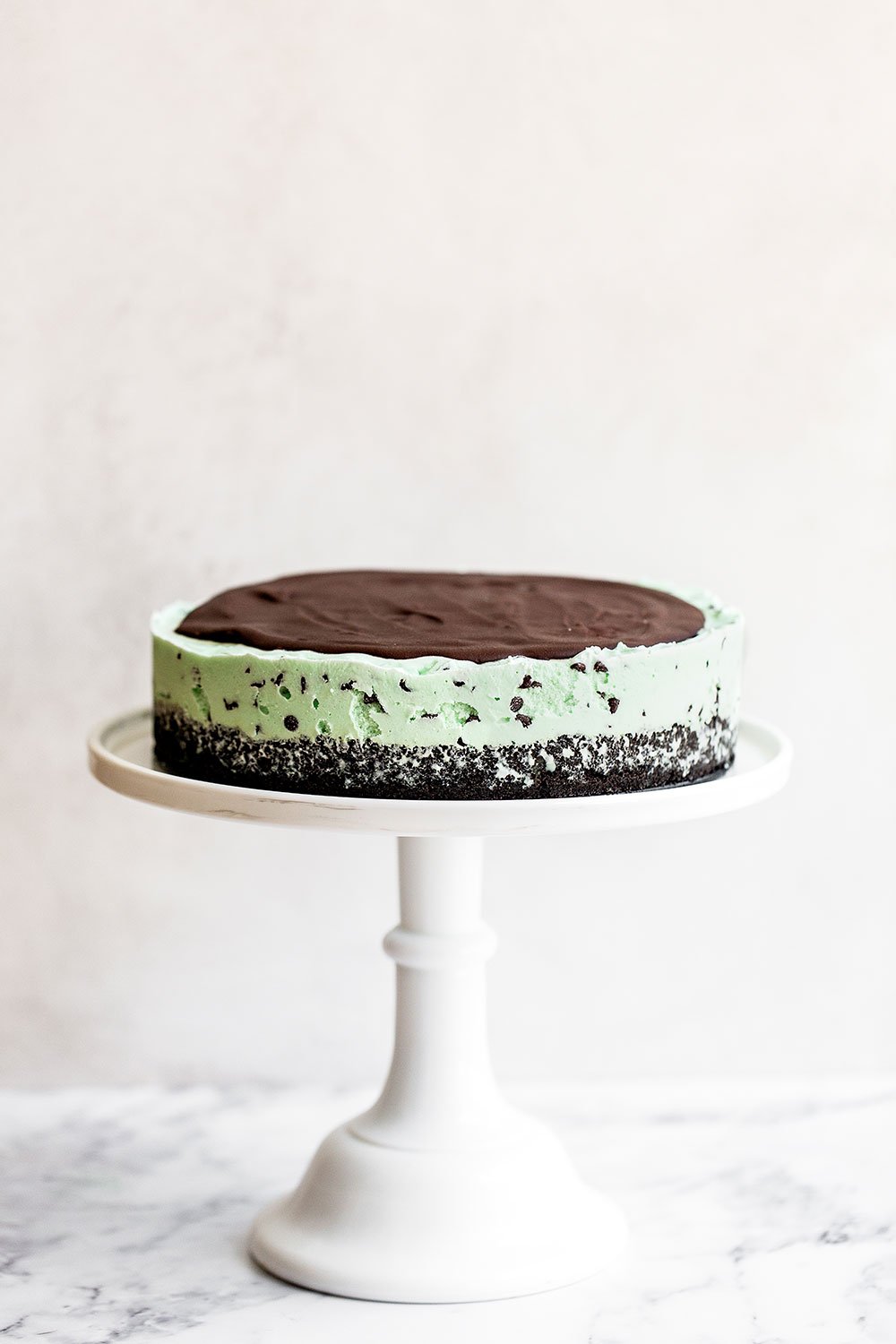 Frozen mint chocolate chip pie on a tall cake pedestal 