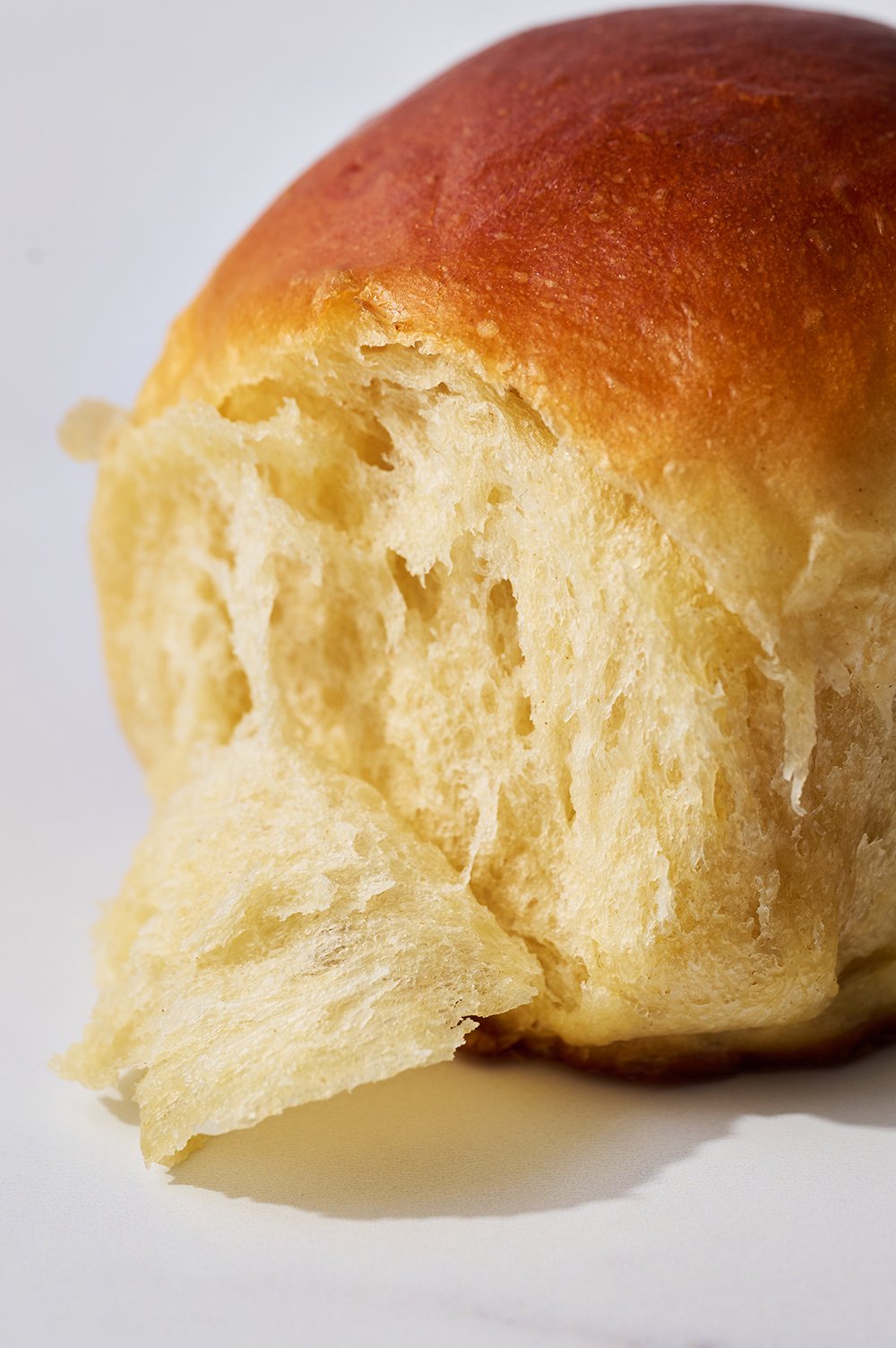 a piece of the bread being pulled away from the roll, to show how soft and moist they are.