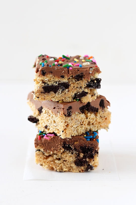 Trashy Rice Crispy Treats loaded with peanut butter, Oreos, and topped with chocolate fudge and sprinkles!