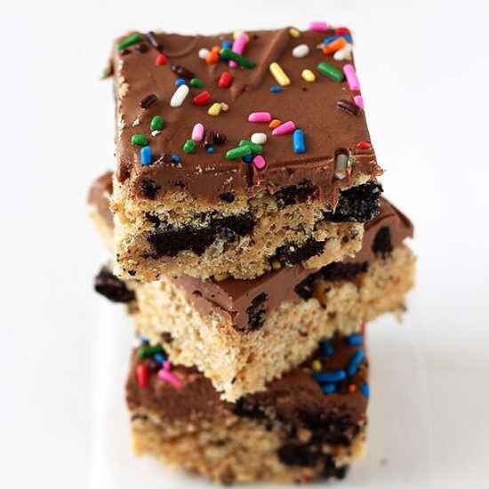 Trashy Rice Crispy Treats loaded with peanut butter, Oreos, and topped with chocolate fudge and sprinkles!