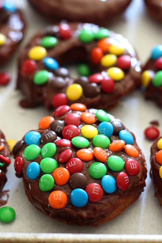 M&M Cake Doughnuts are fried perfection, topped with a thick chocolate glaze and crunchy m&m candies and are way quicker to make than yeast doughnuts!