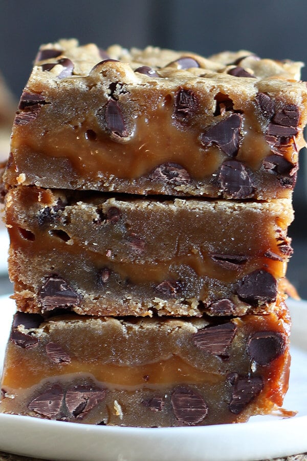 Salted Caramel Cookie Bars feature two layers of chocolate chip cookie sandwiching a thick layer of EASY salted caramel for the perfect salty sweet treat. No mixer required!