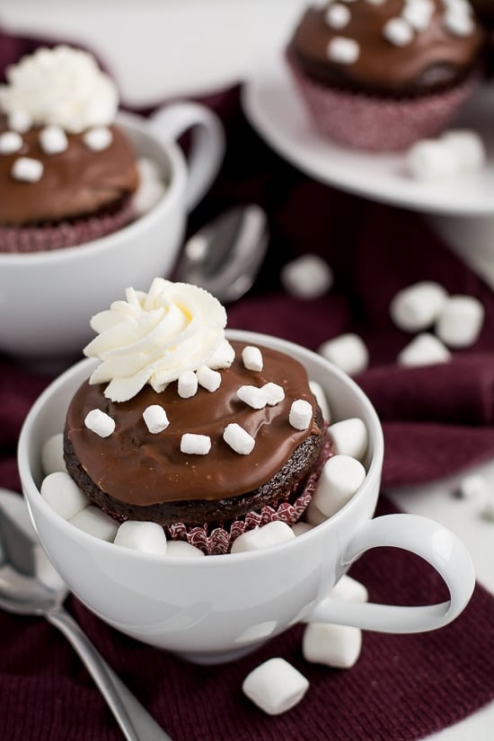 Curl up next to the fireplace with these Hot Chocolate Cupcakes dipped in chocolate frosting, sprinkled with marshmallows, and topped with whipped cream.