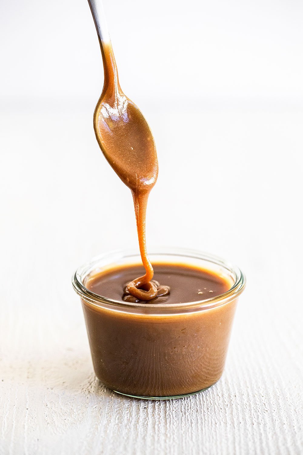 Butterscotch sauce in a jar with a spoon