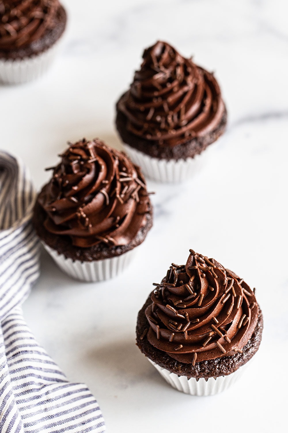 chocolate cupcakes with chocolate frosting on a white background