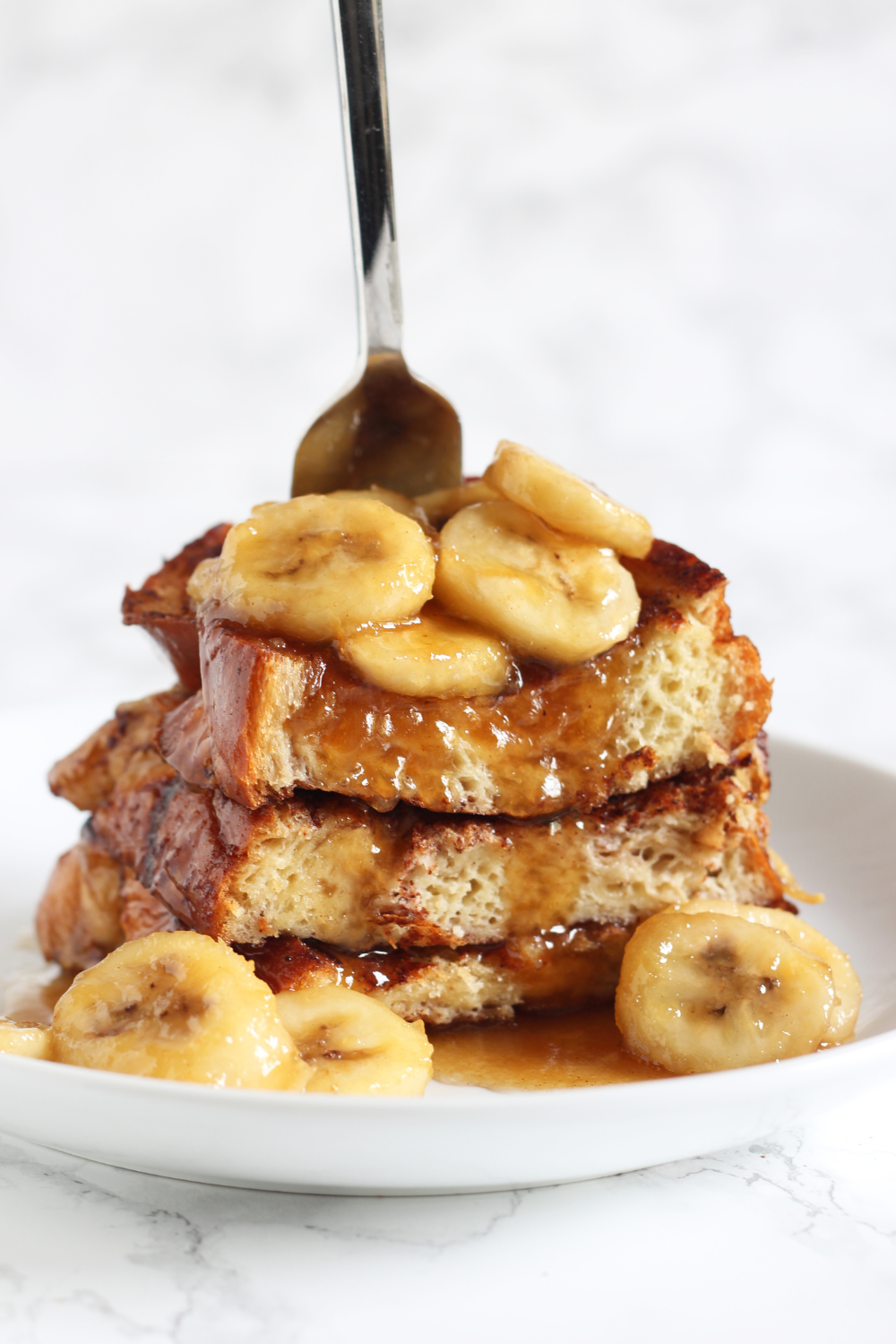 stack of bananas foster French toast with a fork in it