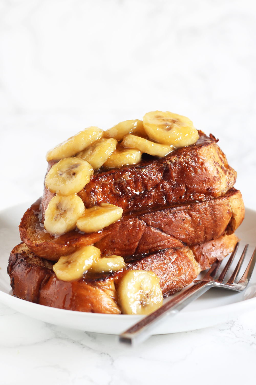 stack of challah French Toast, topped with a decadent bananas topping