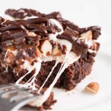 Rocky Road Brownies have a rich chocolate brownie base topped with a layer of puffy marshmallows, sprinkled with chocolate chips and almonds, and drizzled with chocolate frosting.