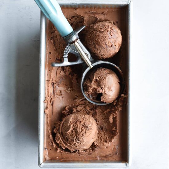 tin filled with homemade death by chocolate ice cream and a blue ice cream scoop