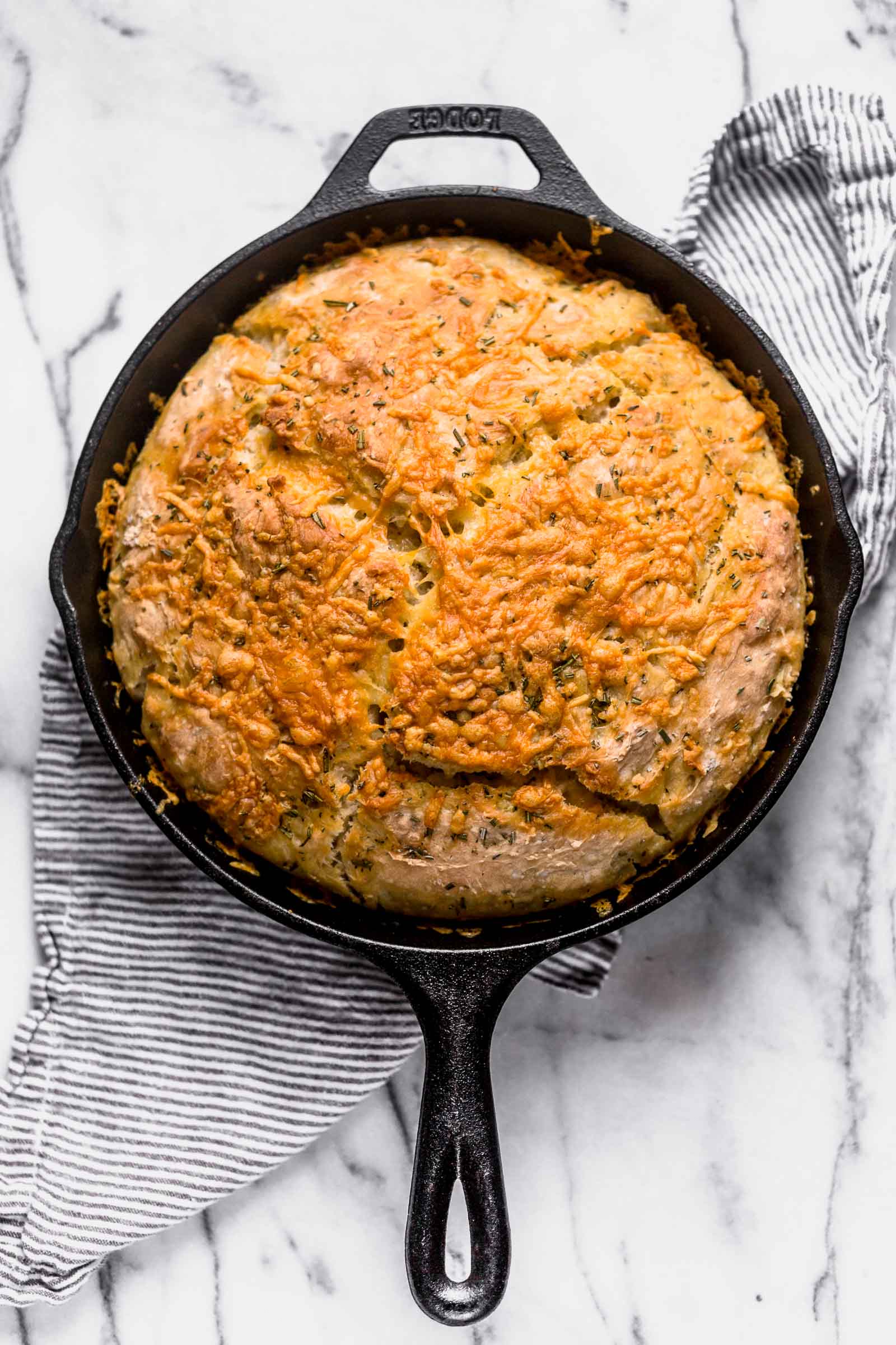 No Knead Rosemary Parmesan Skillet Bread features a super easy homemade dough that comes together in a matter of minutes! This bread has tons of flavor and a crispy cheesy crust.