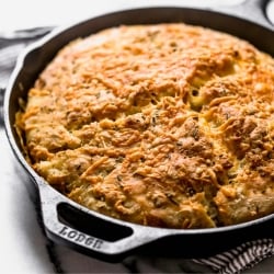 freshly baked rosemary bread in a skillet, ready to serve.