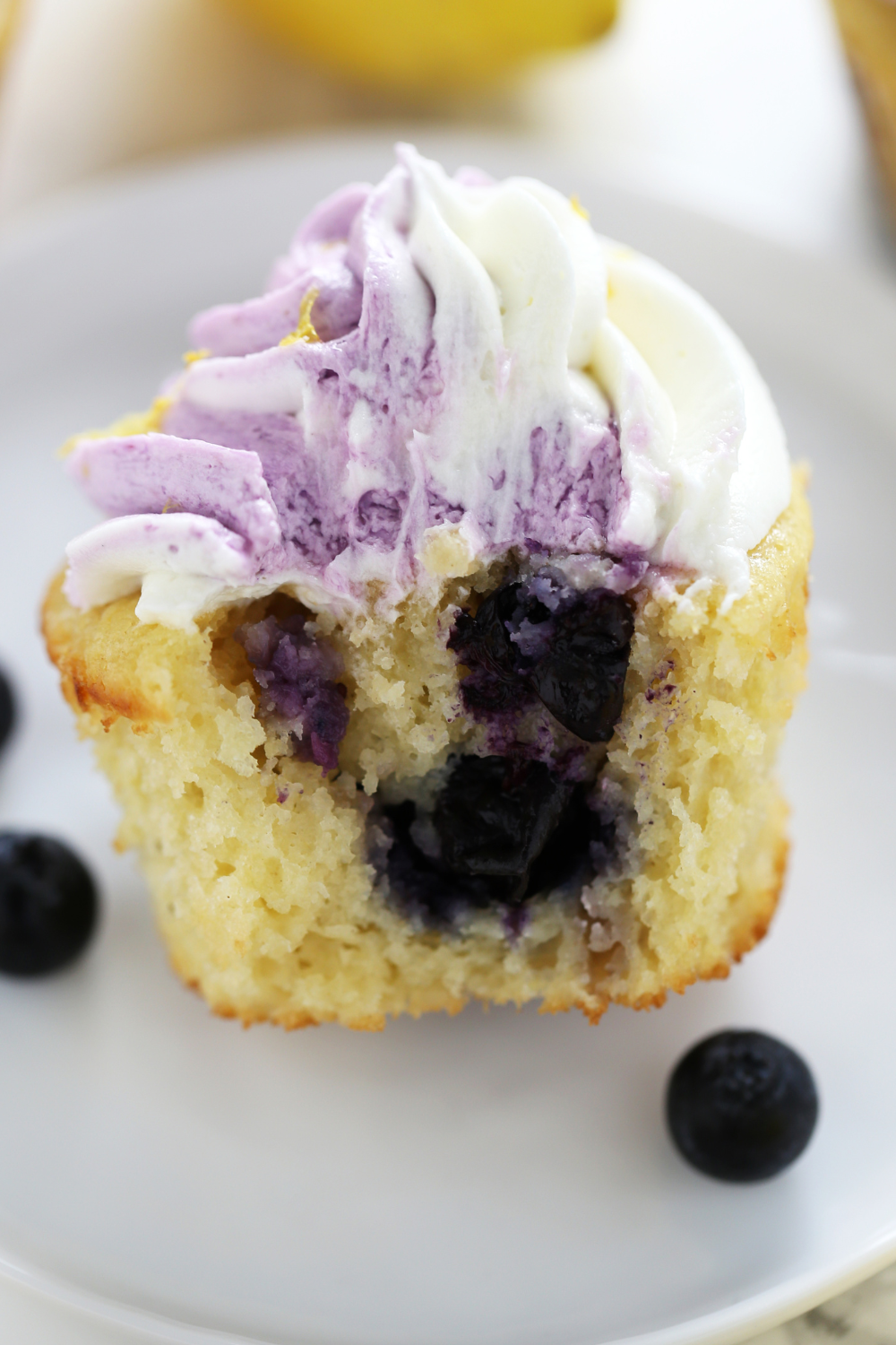 a cupcake bitten in half, so you can see the blueberries inside.
