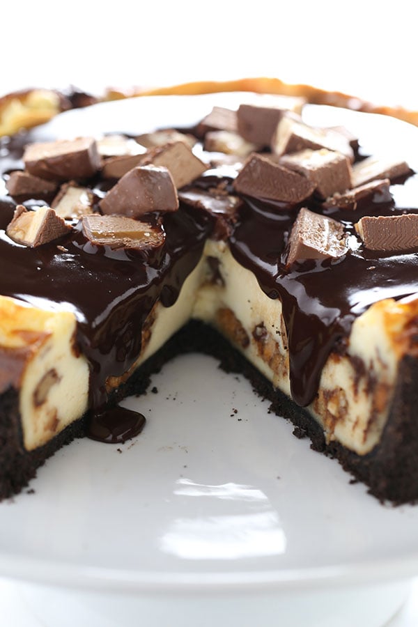 Leftover Halloween Candy Cheesecake using up ALL those Snickers, Twix, Reese's, Milkyway taking up space in your pantry in one over-the-top cheesecake recipe!