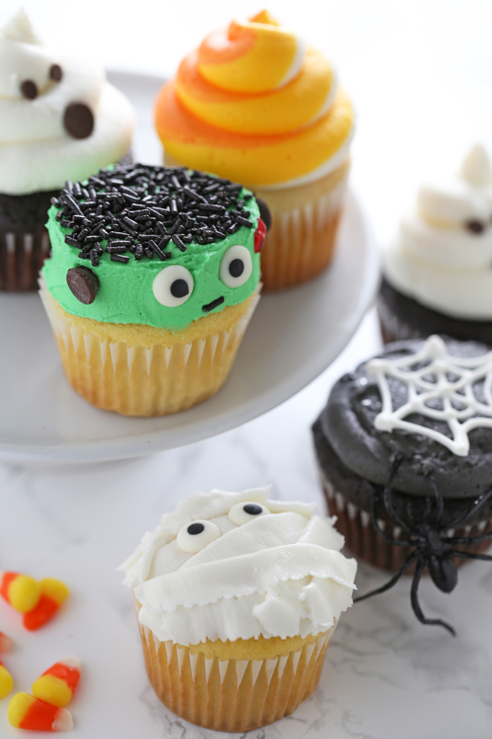 a collection of five fun Halloween cupcakes, all decorated differently