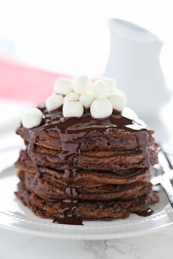 Hot Chocolate Pancakes feature rich chocolate buttermilk pancakes with a thick chocolate fudge topping and garnish with mini marshmallows. 