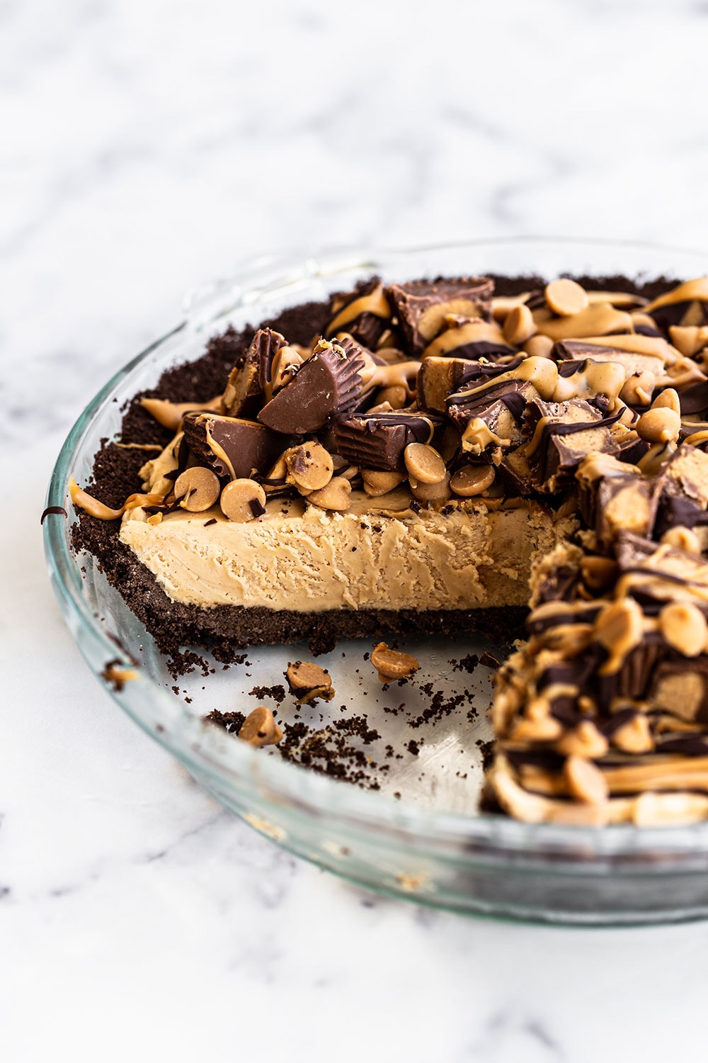 Simple homemade peanut butter pie in glass pie pan with slices already cut out to show the silky, delicious filling. Perfect for an Easter dessert. 