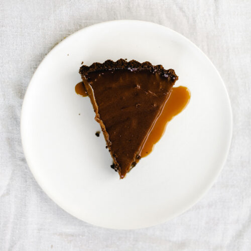 Nutella Caramel Tart features a chocolate graham cracker crust, a layer of hidden homemade salted caramel, and a rich Nutella fudge filling. Pure bliss!