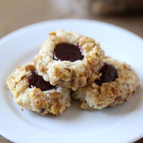 Easy Raspberry Walnut Thumbprint Cookies are buttery, crunchy, and crumbly with dollop of raspberry jam in the center of each!