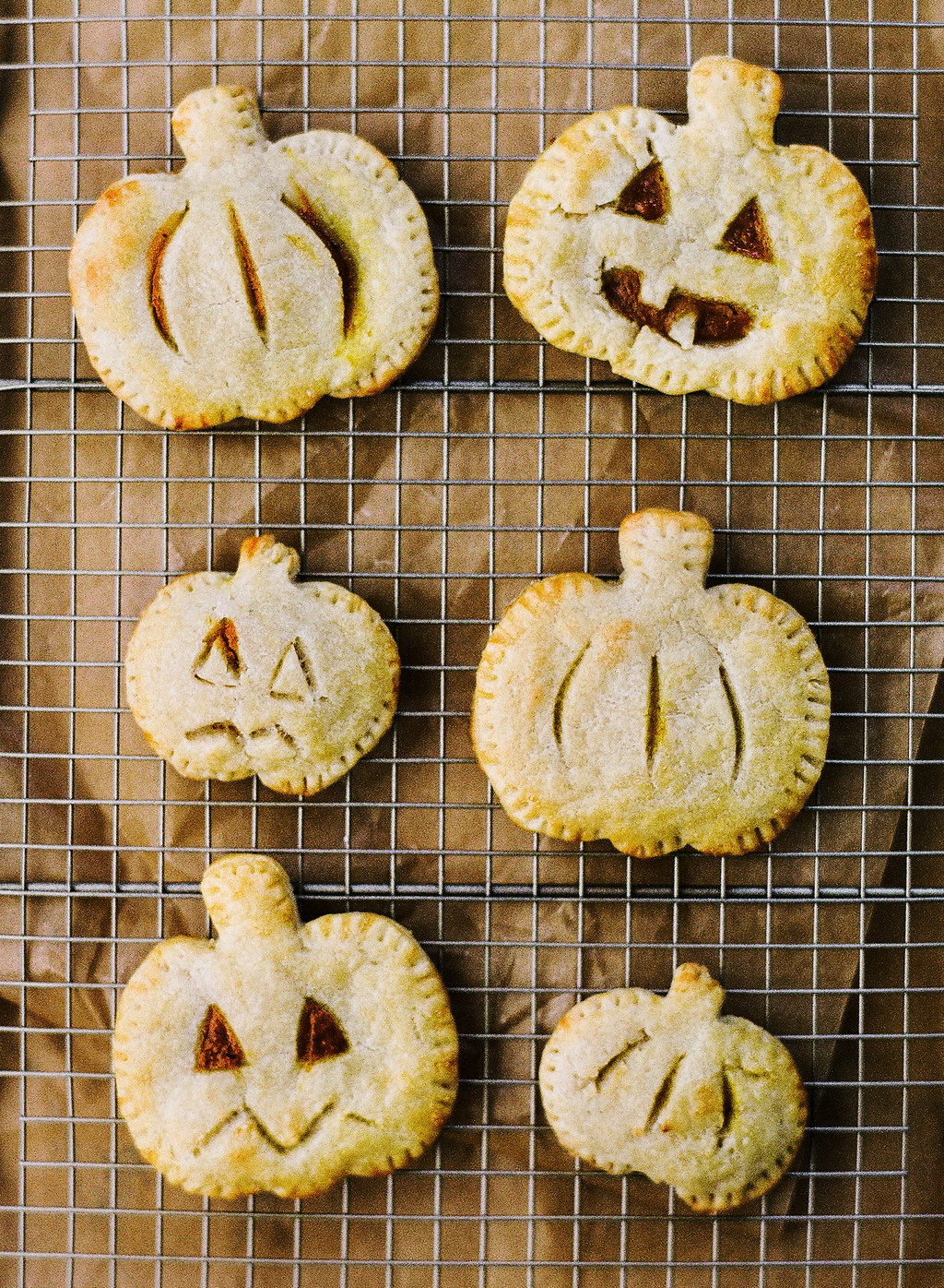 mini jack-o-lantern shaped hand pies, filled with a pumpkin spice pie filling, on a tray, ready to serve