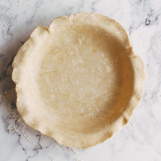 Pie dough rolled out and draped into pie dish