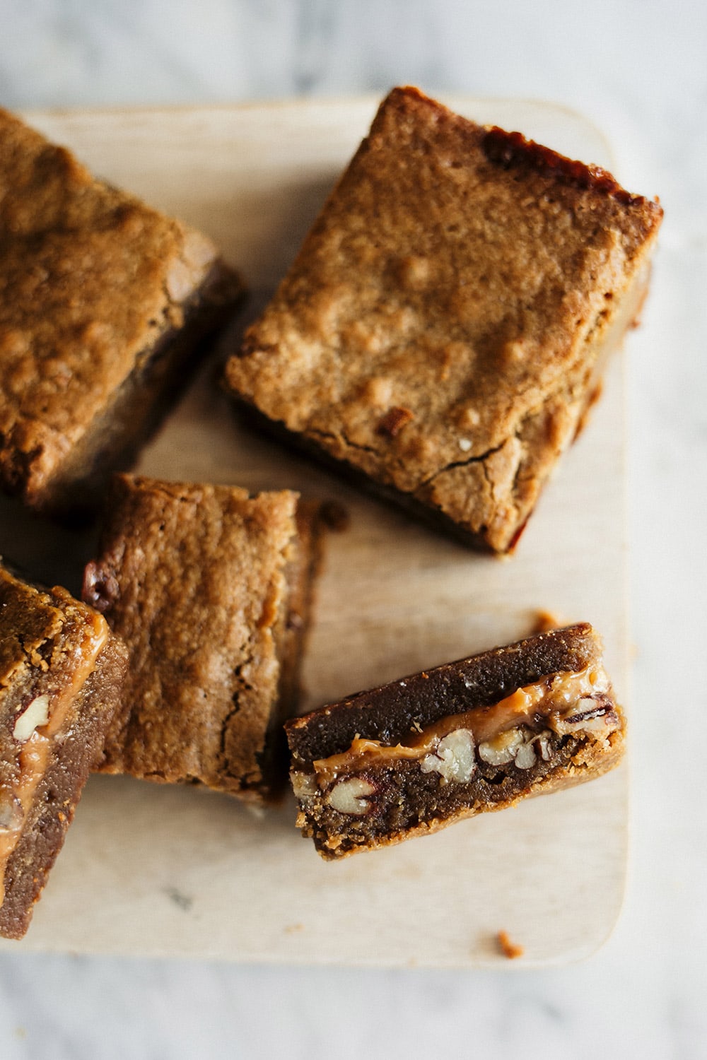 Caramel Pecan Blondies feature an ultra chewy brown sugar blondie with a hidden layer of rich, gooey, and crunchy caramel pecan filling. Out of this world!