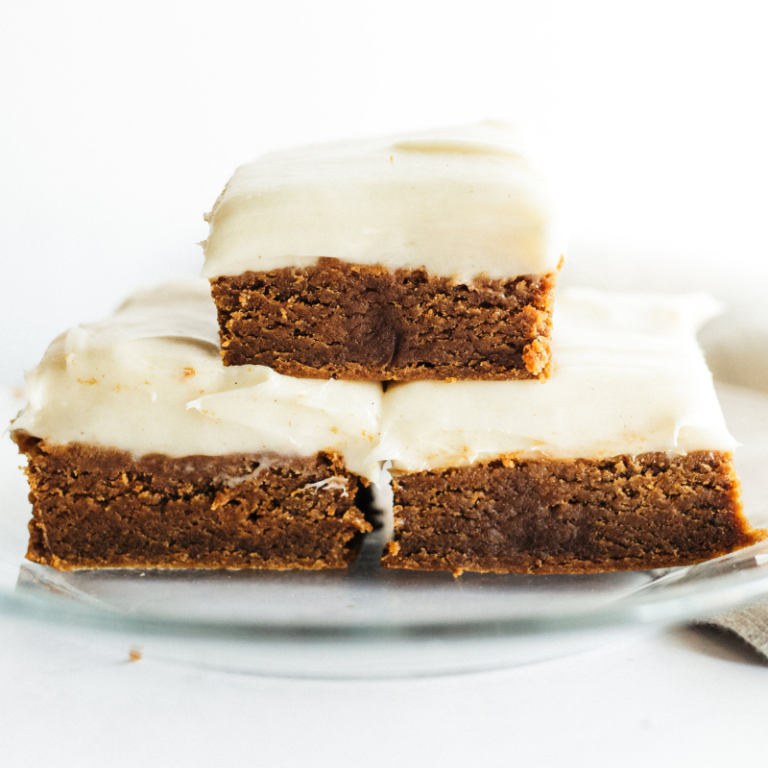 s stack of gingerbread cookie bars with cream cheese frosting.