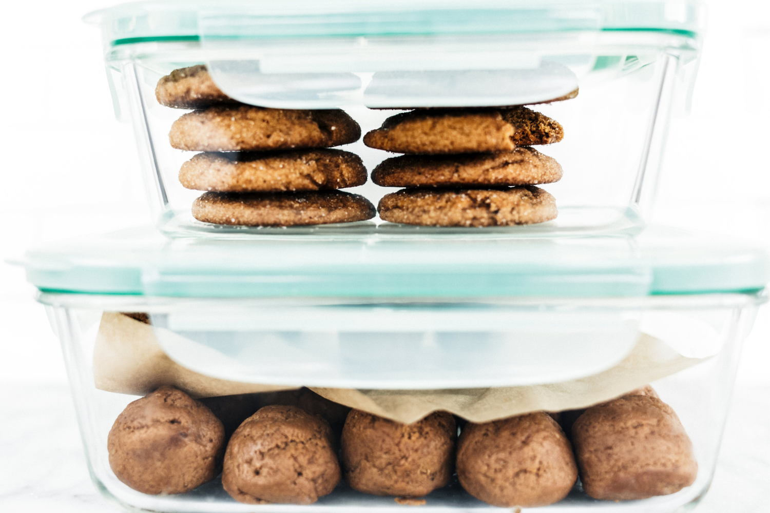 airtight containers full of baked and unbaked cookies.