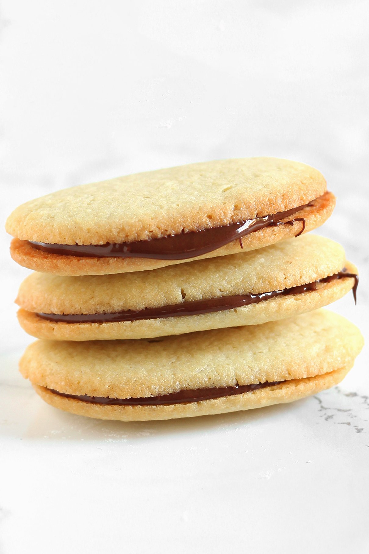 stack of homemade milano cookies, with melted chocolate between the cookie layers
