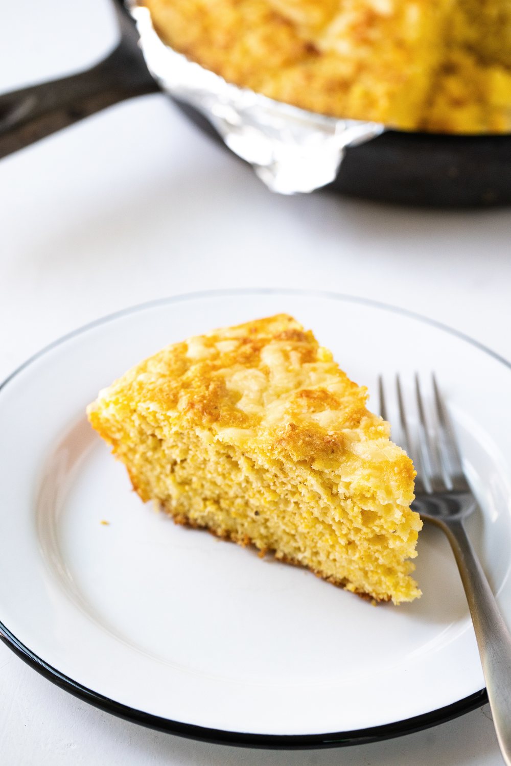 Cheesy Skillet Cornbread is ultra moist, tender, and loaded with cheddar cheese. It can be made in the oven or the grill, making it he perfect summer barbecue recipe!