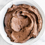 a bowl of chocolate swiss meringue buttercream frosting.