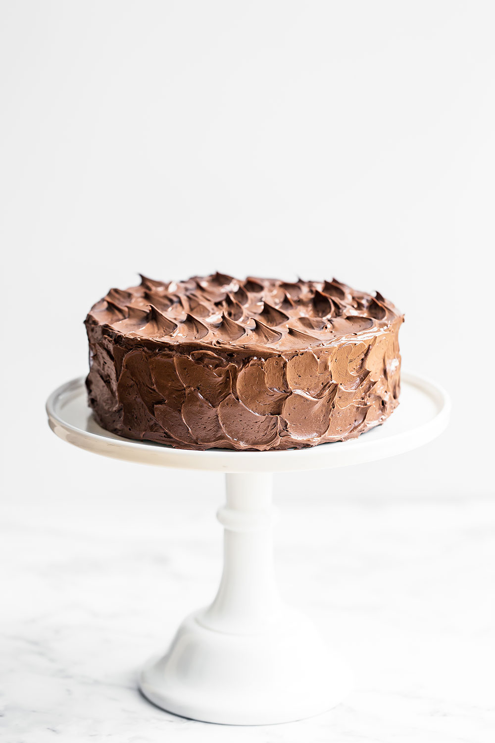 Best Chocolate Cake with Swiss Meringue Buttercream on a cake stand