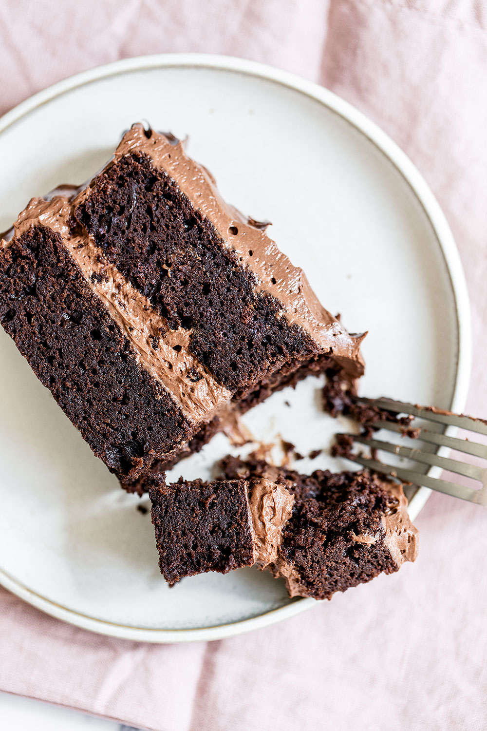 Rich slice of the best chocolate cake recipe with a fork taking a bite