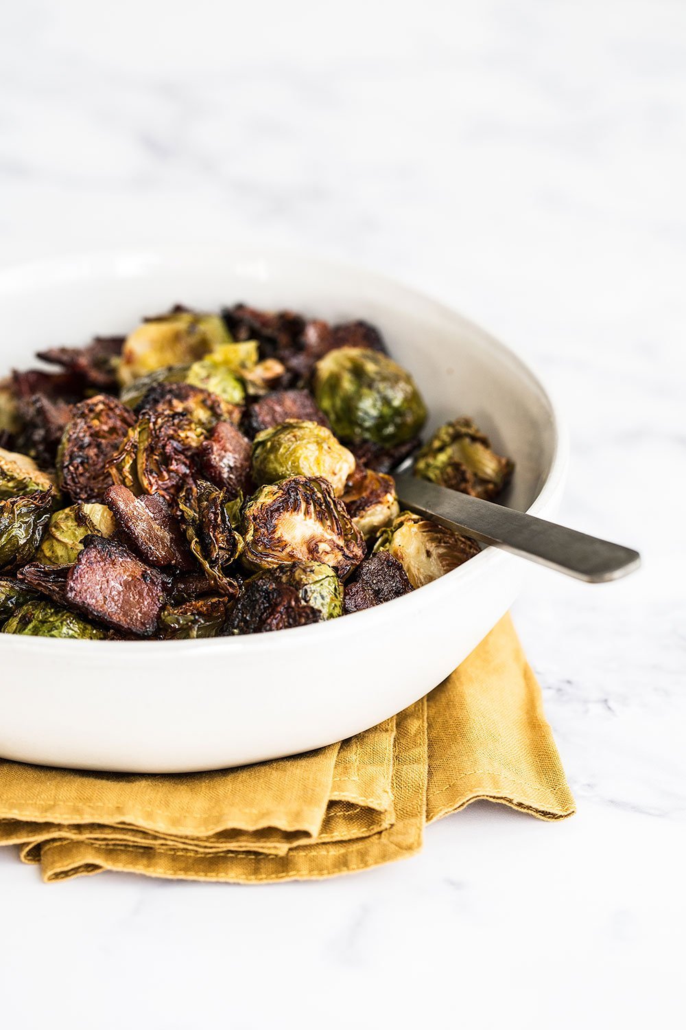 Maple Bacon Brussels Sprouts feature caramelized roasted Brussels sprouts with crispy bits of bacon and a touch of sweetness from the maple syrup. One pan three ingredient recipe!