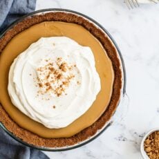 a whole unsliced Butterscotch Pie, topped with fresh whipped cream.