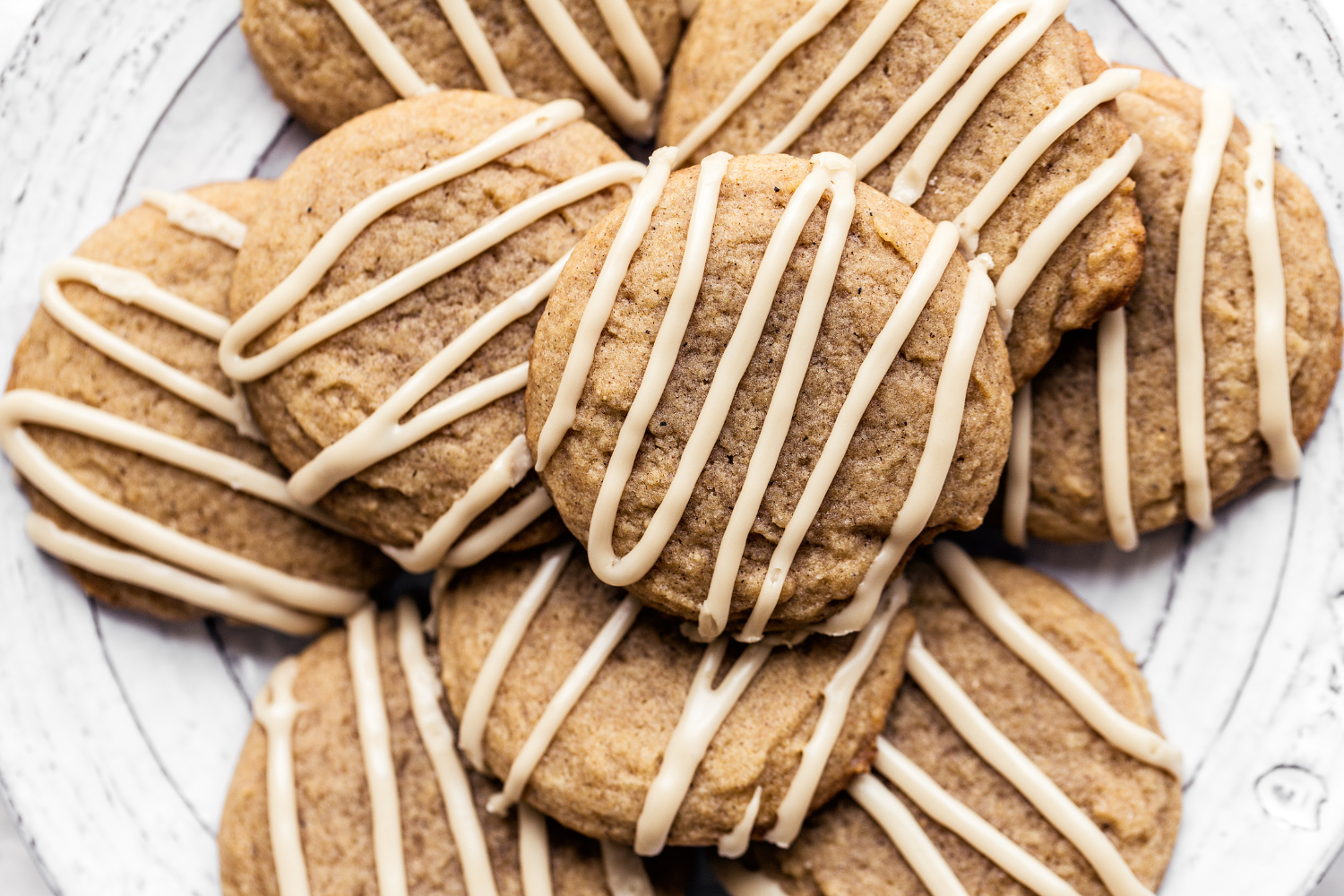 chai cookies neatly drizzled with espresso glaze, on a plate to serve.