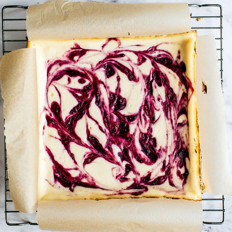 the whole slab of cranberry swirl cheesecake bars on a cooling rack. So pretty!