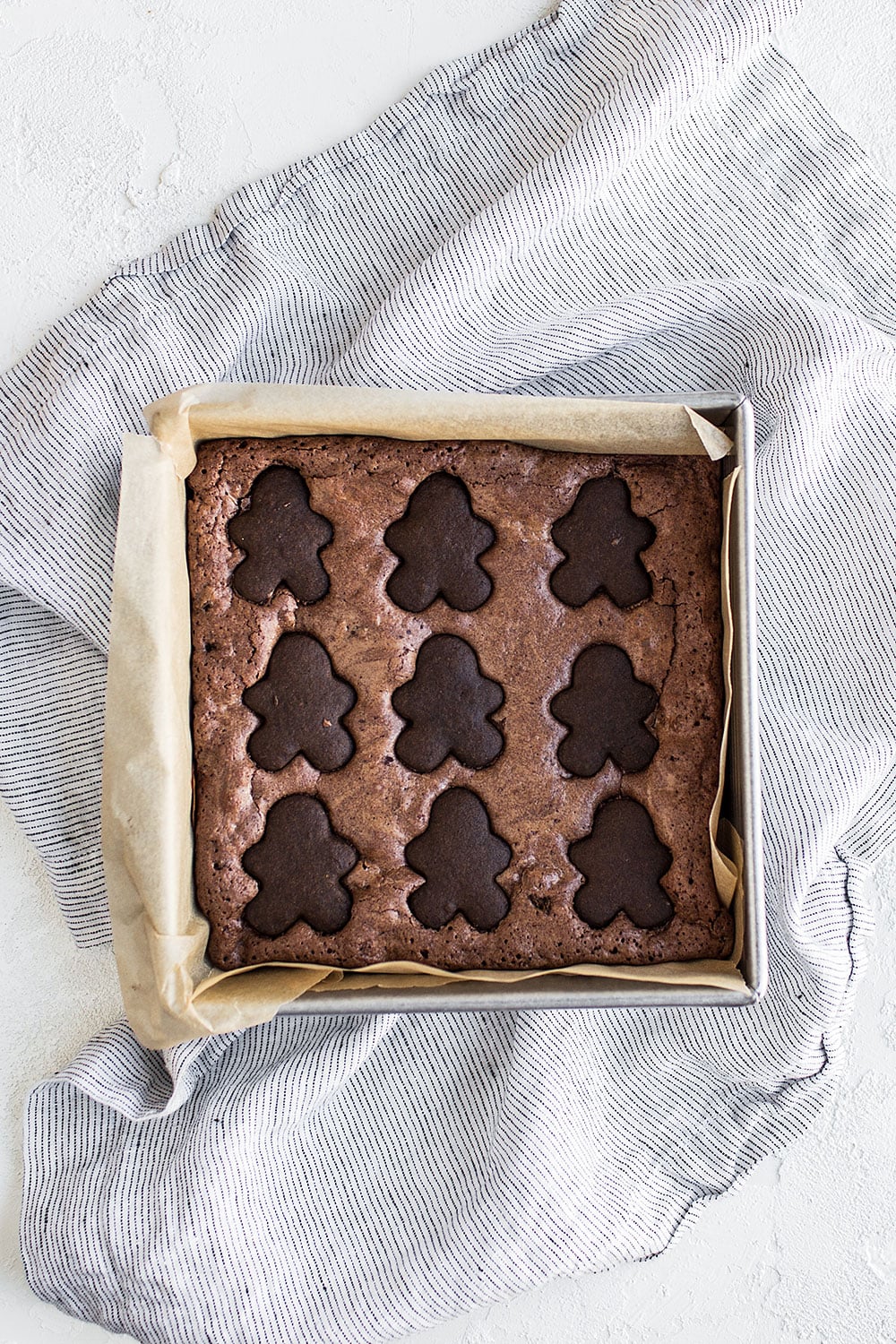 Gingerbread Brownies feature a thick and fudgy spiced brownie studded with crumbled gingerbread cookies and topped with adorable mini gingerbread men for a perfectly festive Christmas dessert!