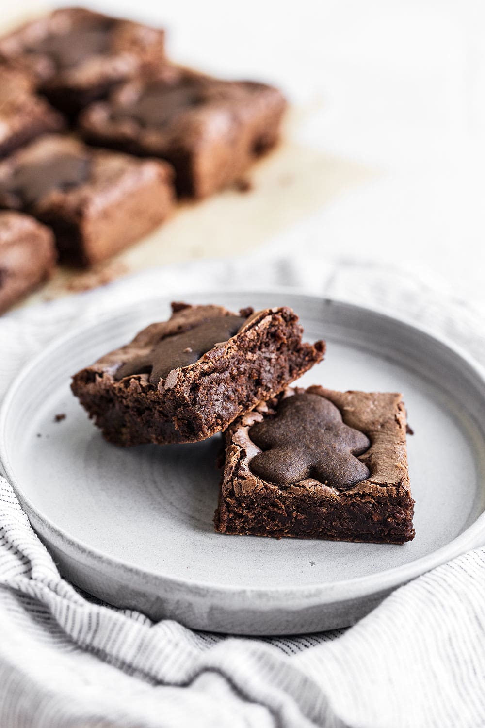 Gingerbread Brownies feature a thick and fudgy spiced brownie studded with crumbled gingerbread cookies and topped with adorable mini gingerbread men for a perfectly festive Christmas dessert!