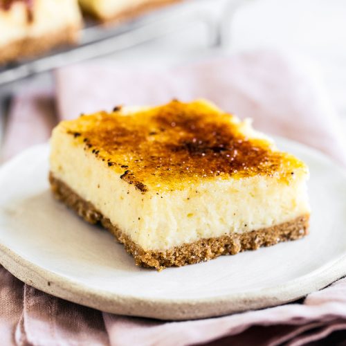 a slice of crunchy sugar-topped creme brulee cheesecake sitting on a plate, ready to serve